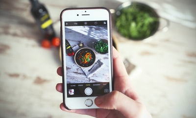 使用银iPhone 6人捕捉蔬菜食品
